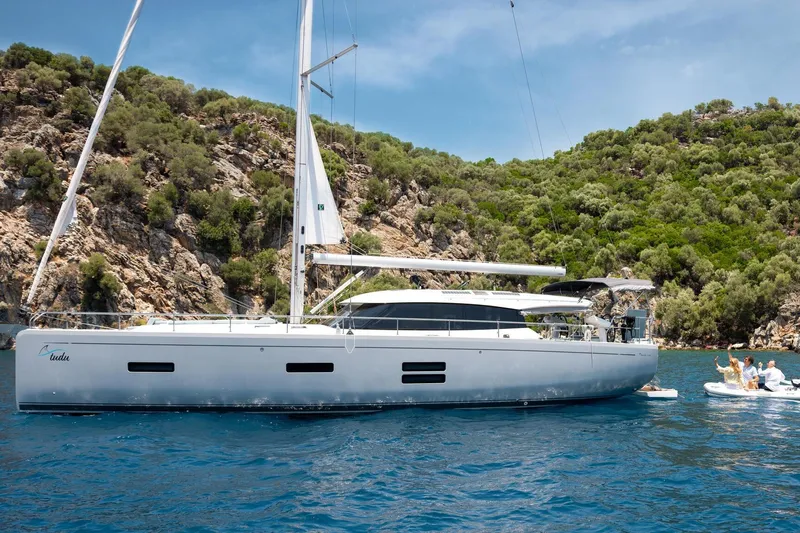  Yacht Photos Pics 2026 Moody 48DS yacht anchored in scenic bay with lush greenery and clear blue water.