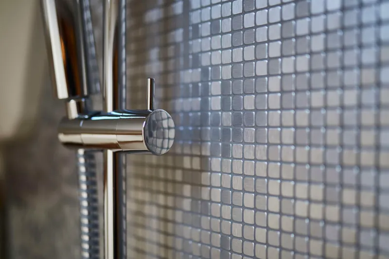  Yacht Photos Pics Close-up of modern chrome faucet against mosaic tile wall, Moody 48DS, 2026.