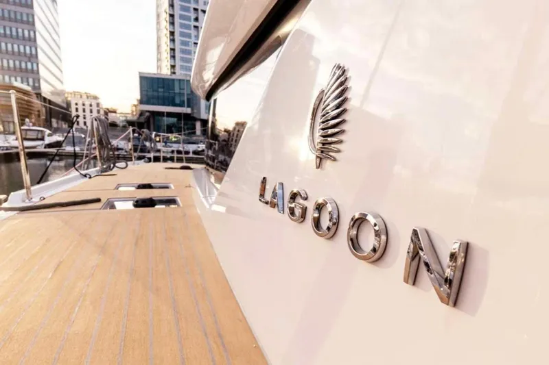  Yacht Photos Pics Luxurious yacht deck with "Lagoon" emblem, cityscape background, Moody 48DS 2026 model.
