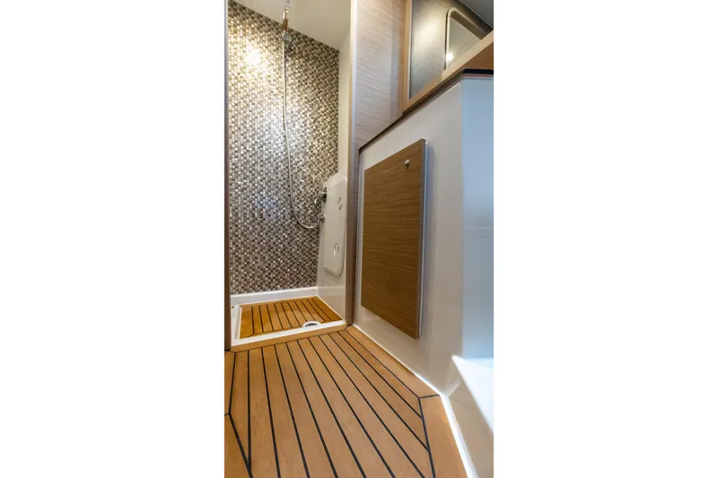  Yacht Photos Pics Luxurious shower area in 2026 Moody 48DS yacht with wood flooring and mosaic tiles.