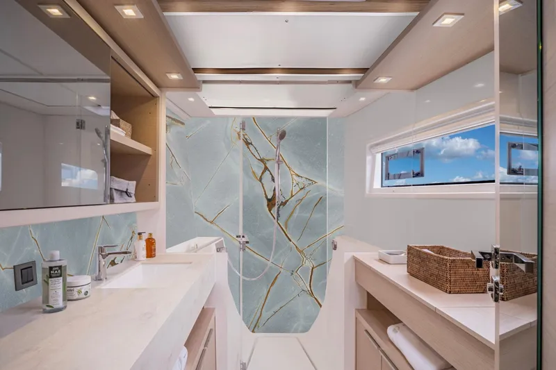  Yacht Photos Pics Luxurious yacht bathroom with marble accents, modern fixtures, and ocean view window, Moody 48DS 2026 model.