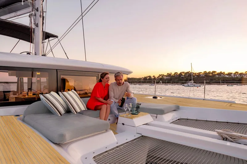  Yacht Photos Pics Couple relaxing on a 2026 Moody 48DS yacht at sunset, enjoying a scenic view.