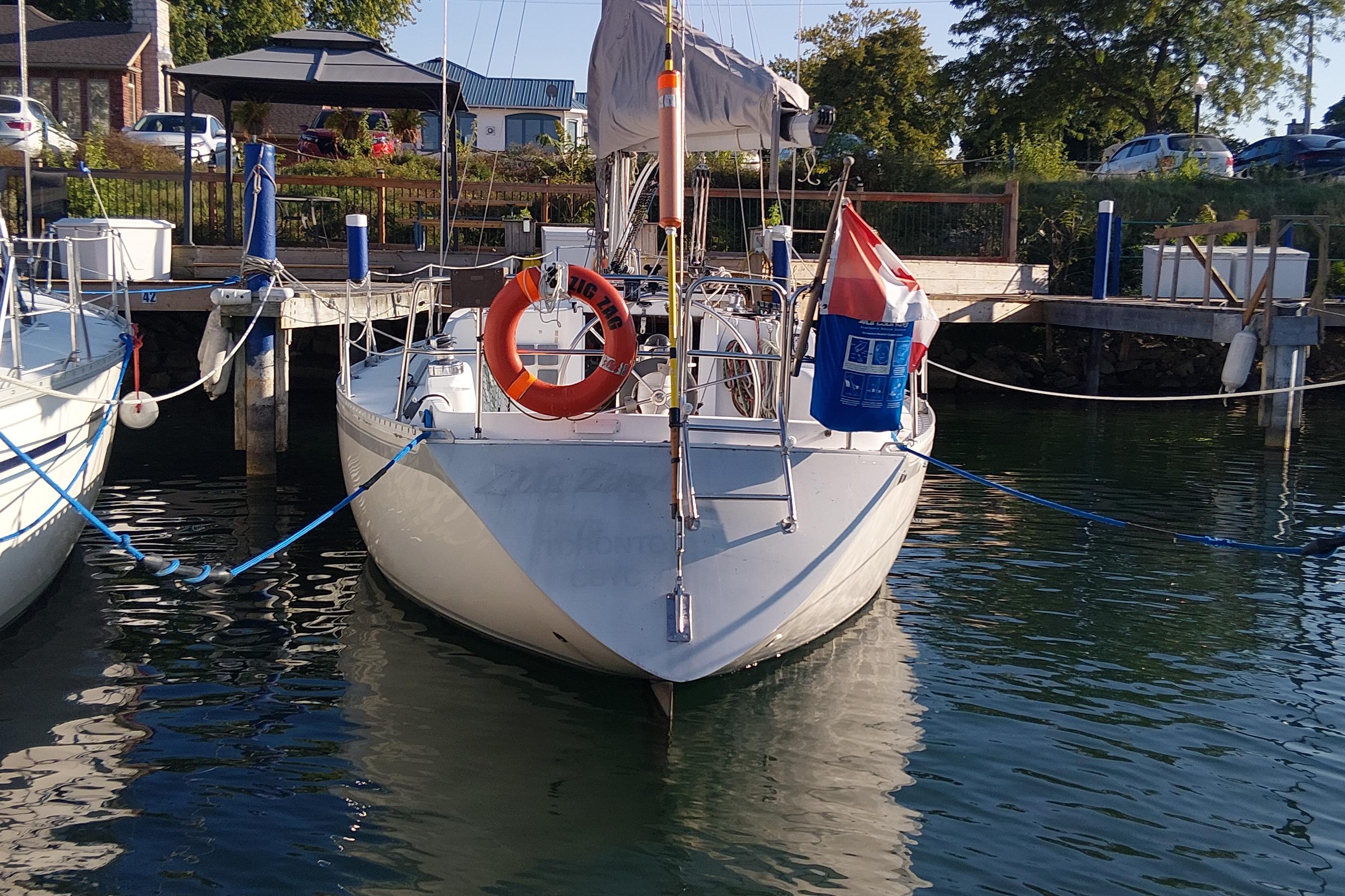 1983 CS 36 Traditional sailboat docked at marina with lifebuoy and flag.