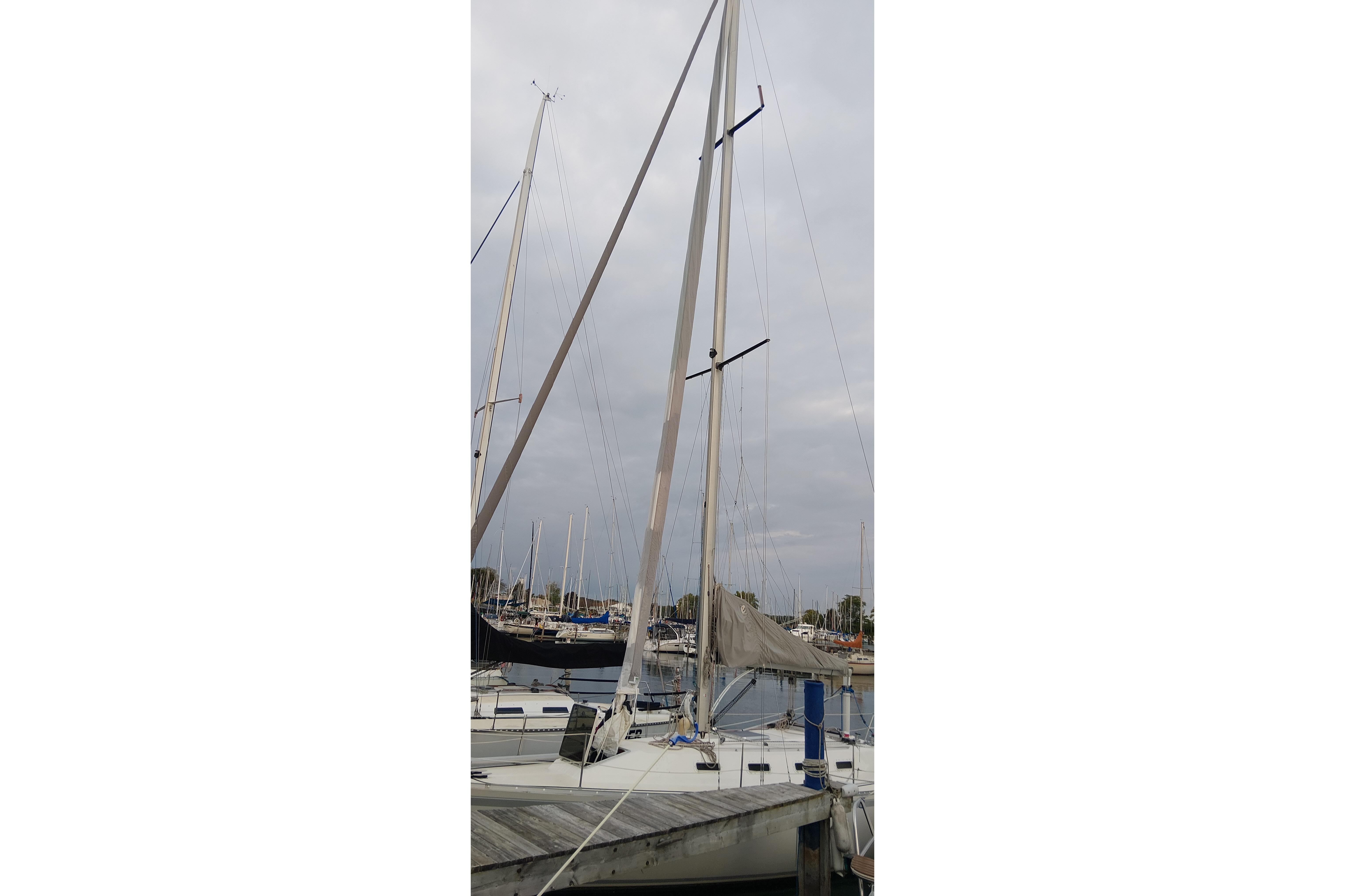 1983 CS 36 Traditional sailboat docked at marina, tall mast visible.