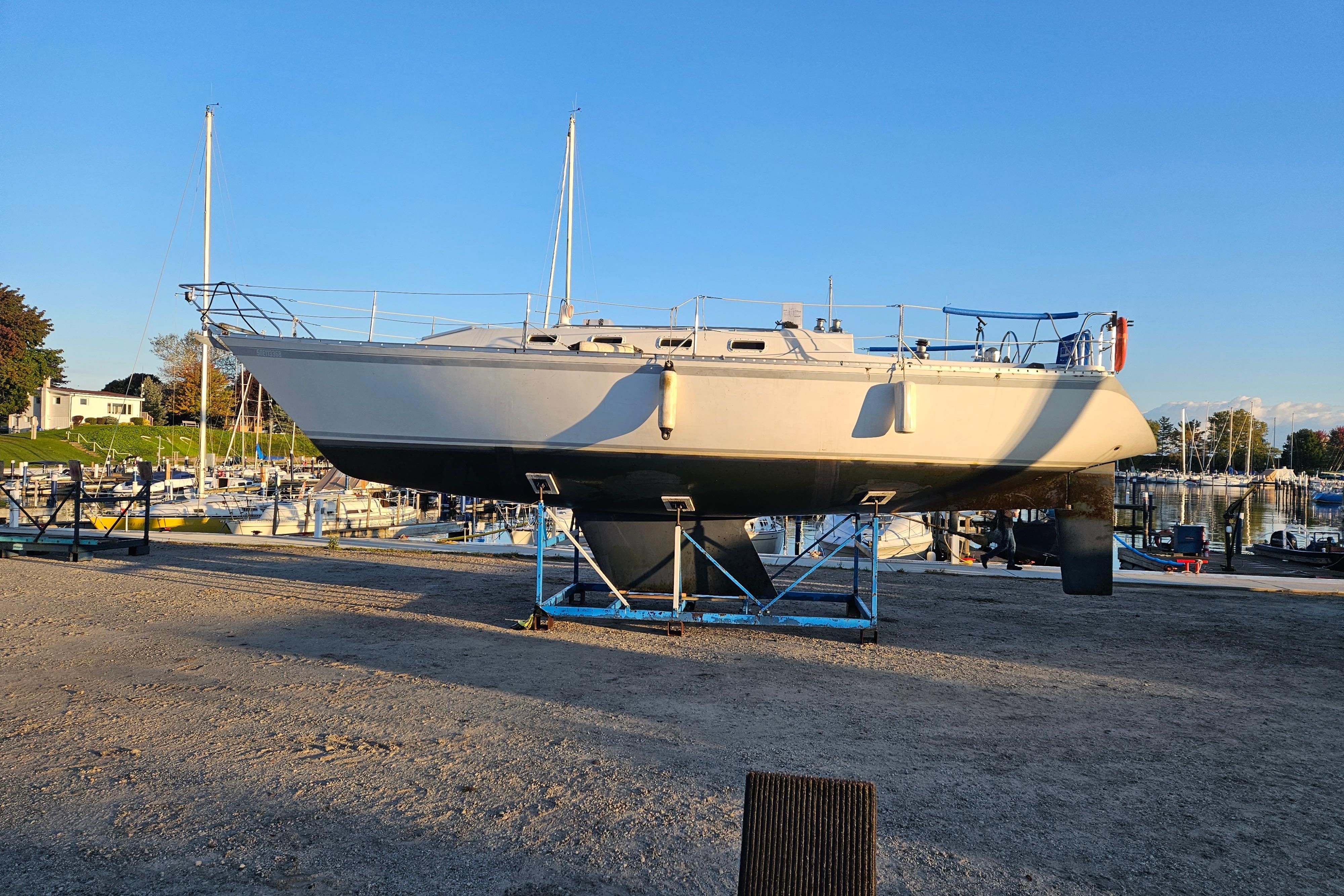 1983 CS 36 Traditional sailboat on dry dock, marina background, clear sky.