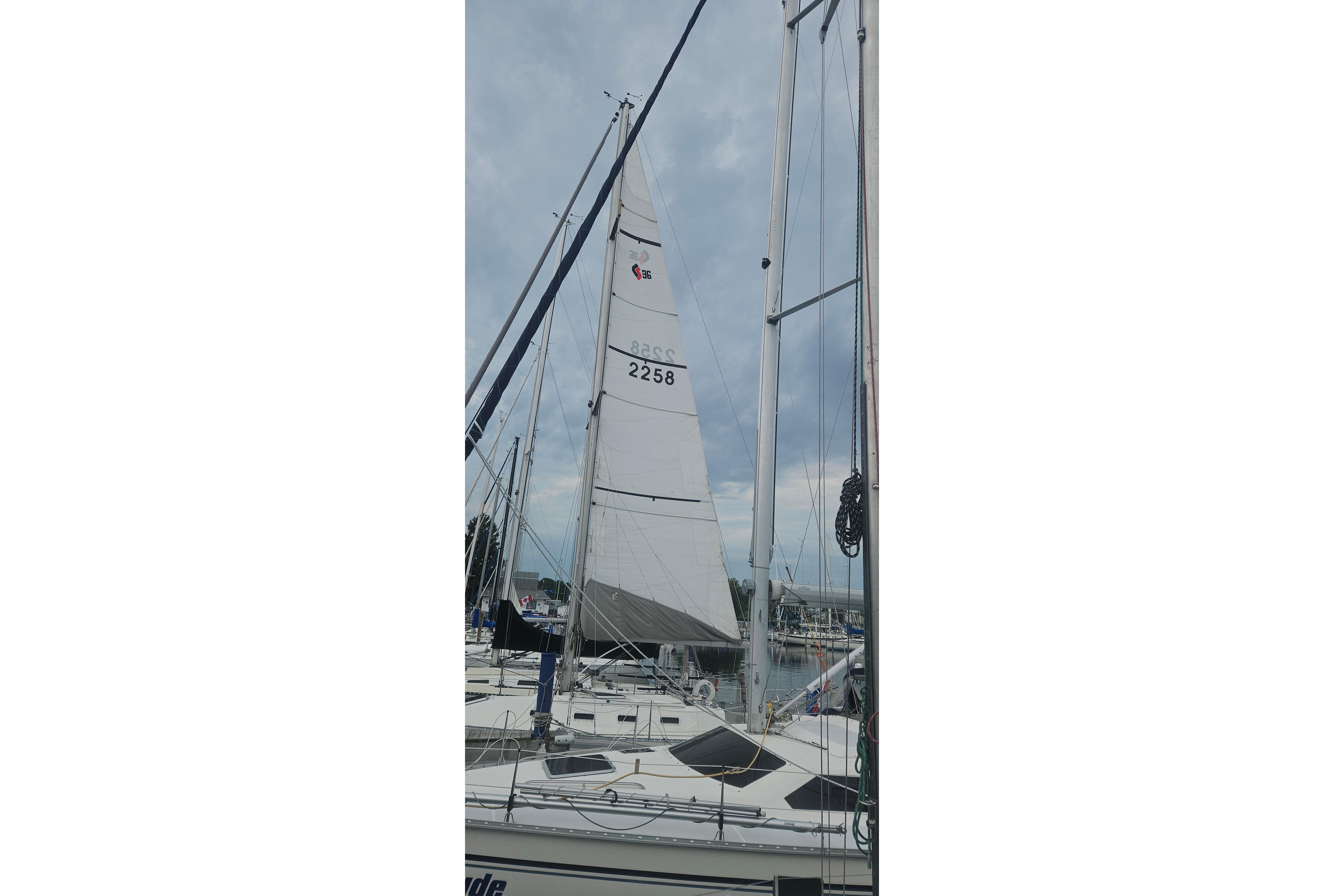 1983 CS 36 Traditional sailboat with raised sails docked at marina.