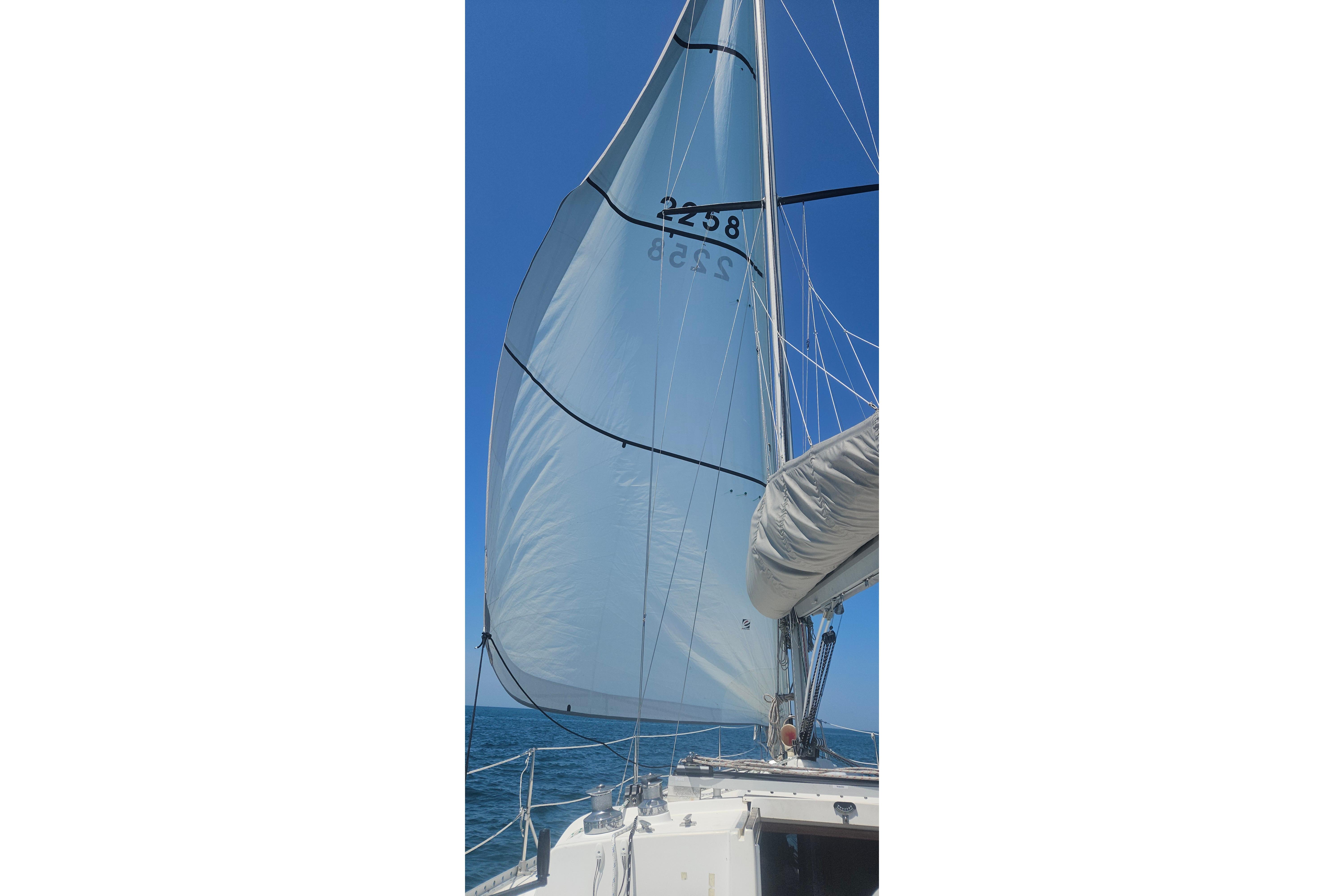Sailing on a 1983 CS 36 Traditional yacht with full sails against a clear blue sky.