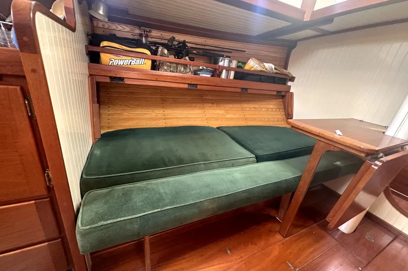 Solimar Yacht Photos Pics Cozy interior of 2000 Sam L. Morse Bristol Channel Cutter 28 with green cushions and wooden table.