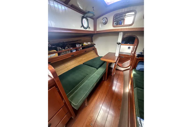 Solimar Yacht Photos Pics Interior of 2000 Sam L. Morse Bristol Channel Cutter 28 with wooden furnishings and green cushions.