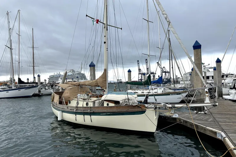 Solimar Yacht Photos Pics 2000 Sam L. Morse Bristol Channel Cutter 28 docked in a marina under cloudy skies.