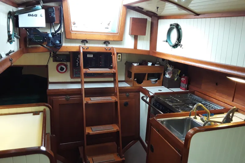 Solimar Yacht Photos Pics Interior of a 2000 Sam L. Morse Bristol Channel Cutter 28, featuring a compact galley and navigation equipment.
