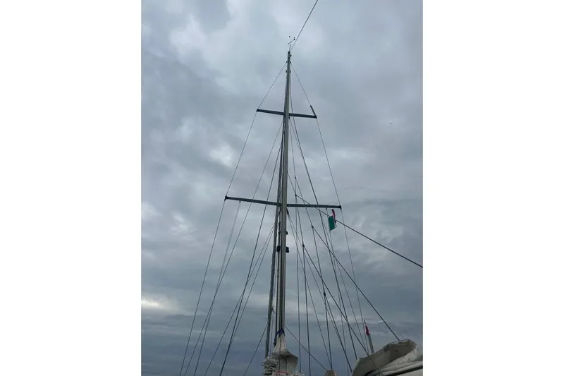 Solimar Yacht Photos Pics Mast of 2000 Sam L. Morse Bristol Channel Cutter 28 against cloudy sky.