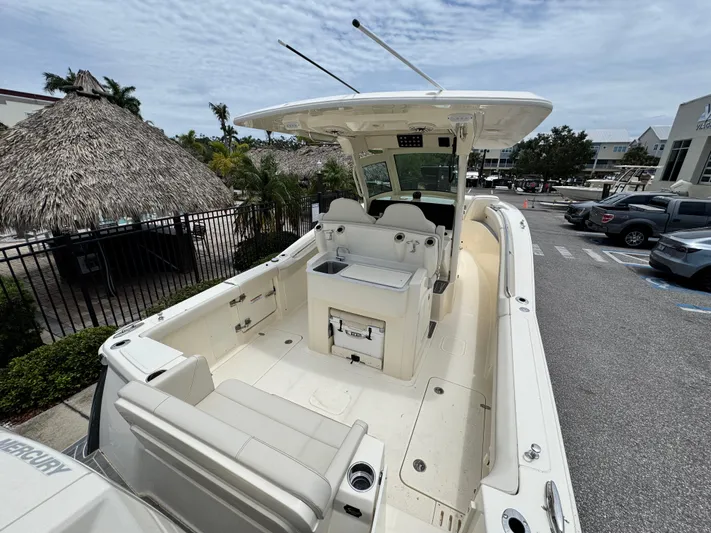  Yacht Photos Pics 2025 Scout 305 LXF boat with spacious deck and seating, parked outdoors.