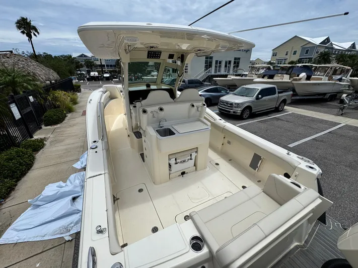  Yacht Photos Pics 2025 Scout 305 LXF boat with spacious deck and seating, parked in a marina.