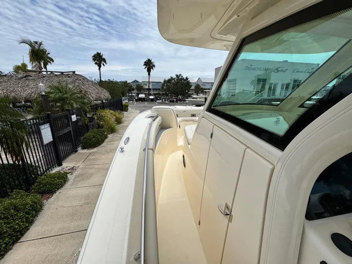  Yacht Photos Pics 2025 Scout 305 LXF boat docked, showcasing sleek design and spacious deck.