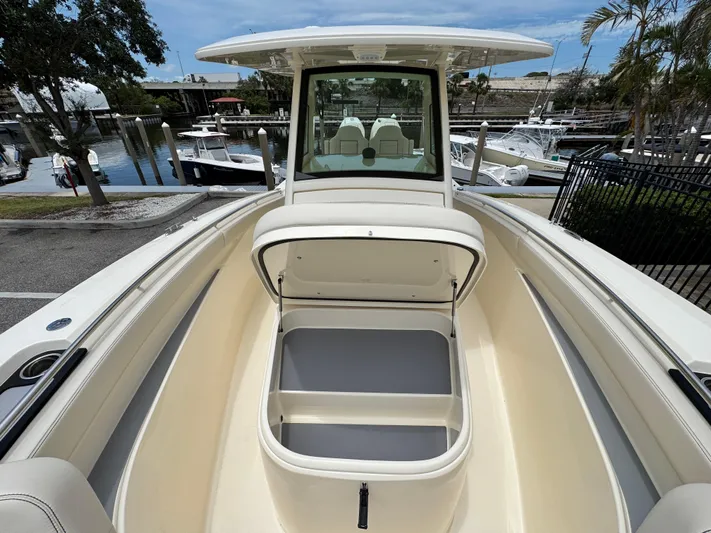  Yacht Photos Pics 2025 Scout 305 LXF boat with open storage compartment, docked at marina.