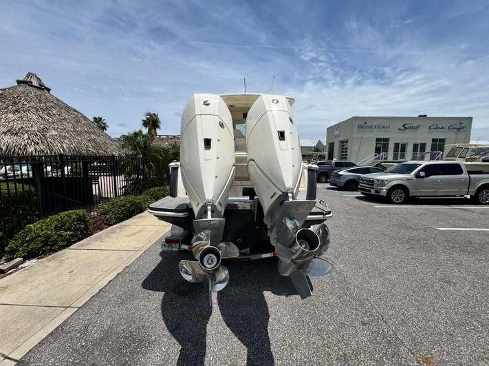  Yacht Photos Pics 2025 Scout 305 LXF boat with dual outboard engines in a parking lot.