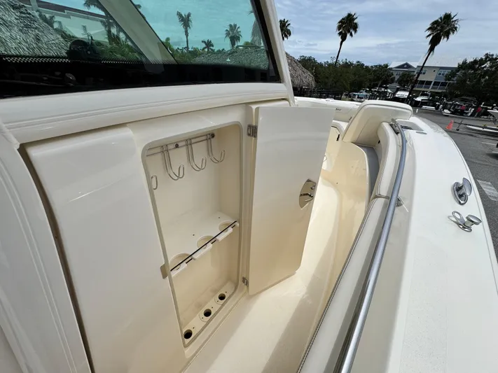  Yacht Photos Pics 2025 Scout 305 LXF boat storage compartment with open door, showcasing hooks and shelves.
