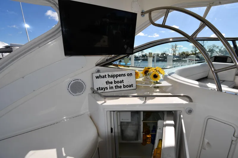  Yacht Photos Pics 2005 Cruisers Yachts 500 Express interior with TV, flowers, and mini-fridge.