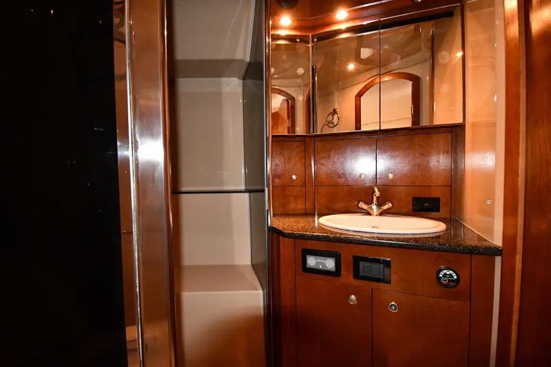  Yacht Photos Pics Luxurious bathroom in 2005 Cruisers Yachts 500 Express with wood cabinetry and modern fixtures.