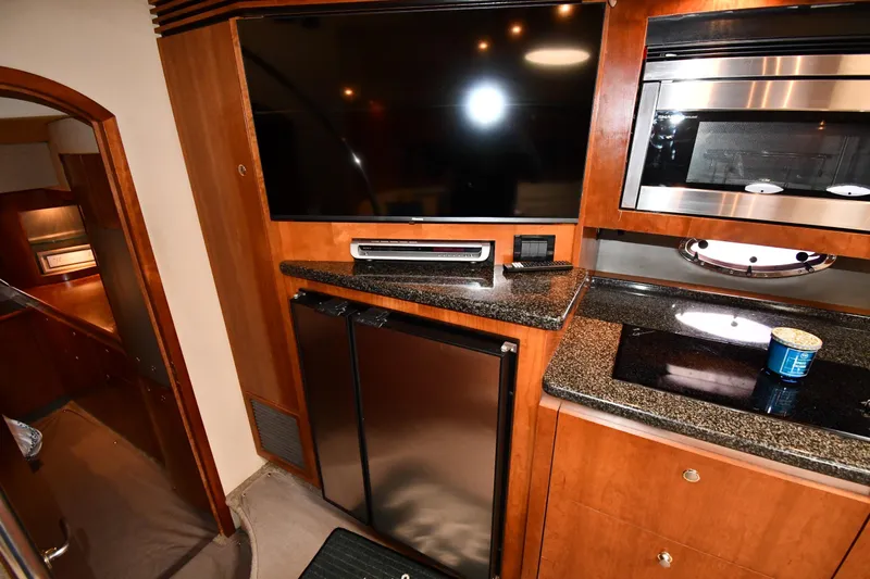 Yacht Photos Pics 2005 Cruisers Yachts 500 Express interior with TV, microwave, and kitchenette.