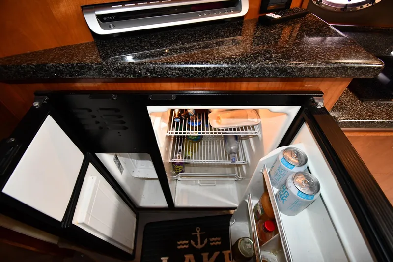  Yacht Photos Pics 2005 Cruisers Yachts 500 Express interior with open mini fridge and granite countertop.