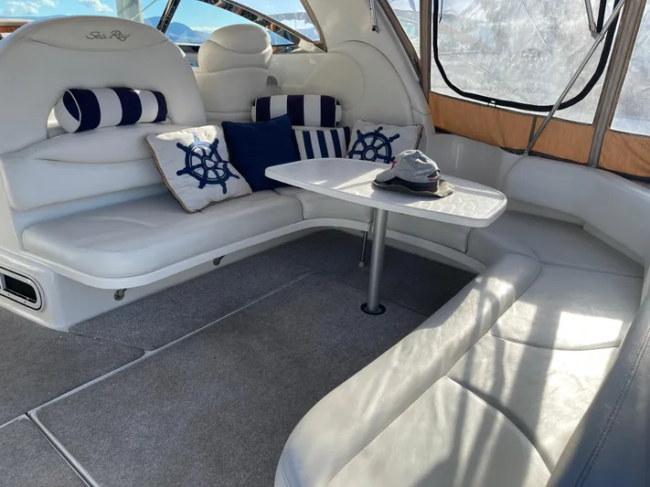  Yacht Photos Pics Interior of 2000 Sea Ray 380 Sundancer with white seating and nautical-themed cushions.