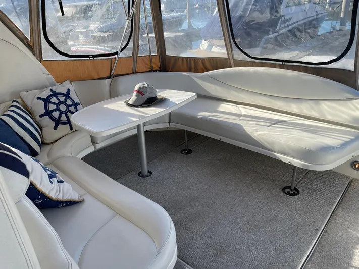  Yacht Photos Pics 2000 Sea Ray 380 Sundancer interior with white seating, table, and nautical-themed pillows.
