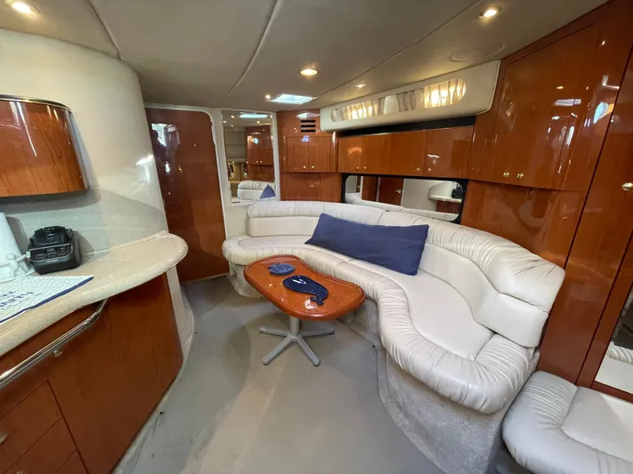  Yacht Photos Pics Luxurious interior of 2000 Sea Ray 380 Sundancer with plush seating and wooden cabinetry.