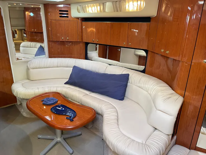  Yacht Photos Pics Luxurious interior of 2000 Sea Ray 380 Sundancer with plush seating and wooden cabinetry.