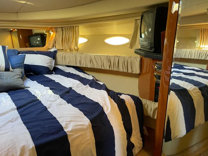  Yacht Photos Pics Interior of 2000 Sea Ray 380 Sundancer with striped bedding and vintage TV.