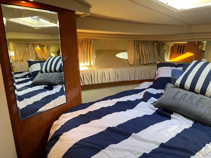  Yacht Photos Pics Cozy cabin interior of 2000 Sea Ray 380 Sundancer with striped bedding and mirror.