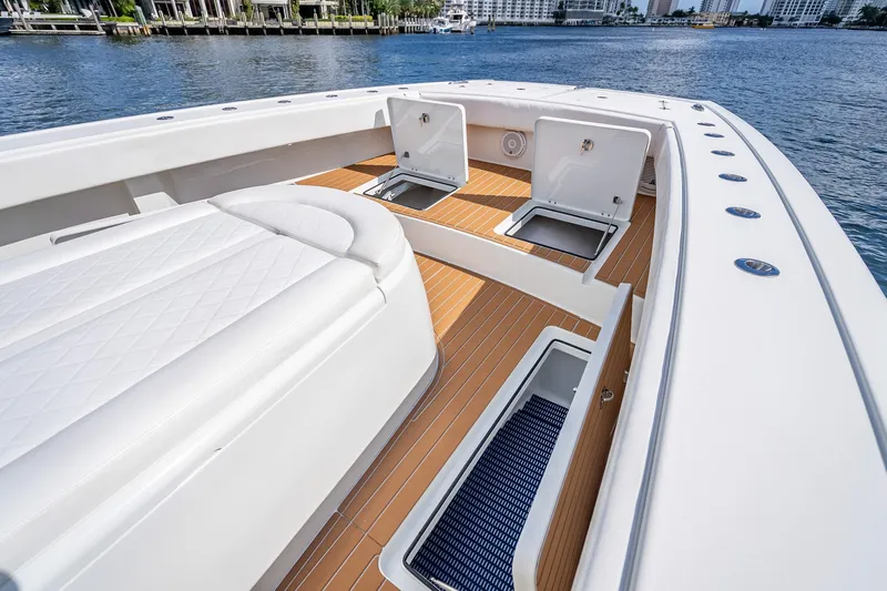  Yacht Photos Pics 2019 Freeman 42LR boat deck with open storage compartments, docked by waterfront buildings.