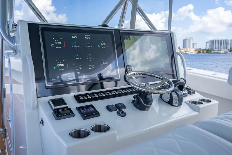  Yacht Photos Pics Control panel of a 2019 Freeman 42LR boat with navigation screens and steering wheel.