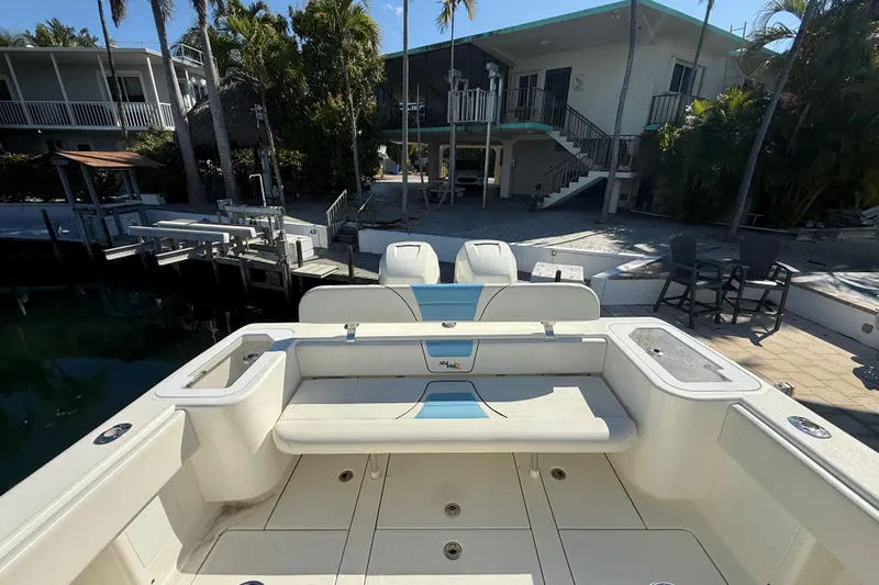  Yacht Photos Pics 2019 SeaVee 340Z boat docked near a waterfront home with palm trees.