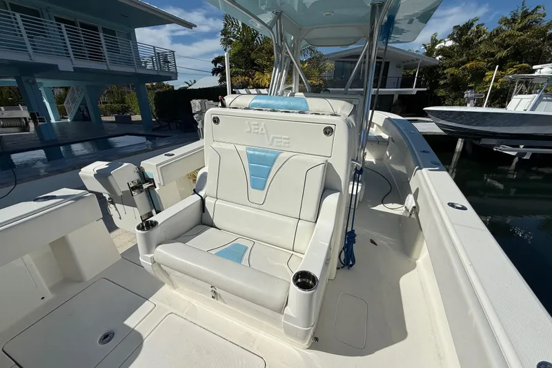  Yacht Photos Pics 2019 SeaVee 340Z boat interior with white and blue seating, docked near modern homes.