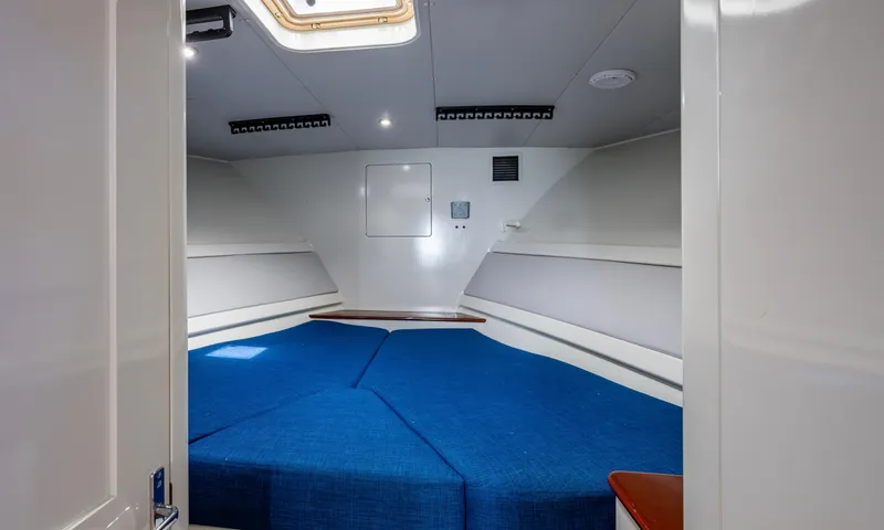 Slippery Slope Yacht Photos Pics Interior cabin of 2005 Gamefisherman 45 Express with blue bedding and white walls.
