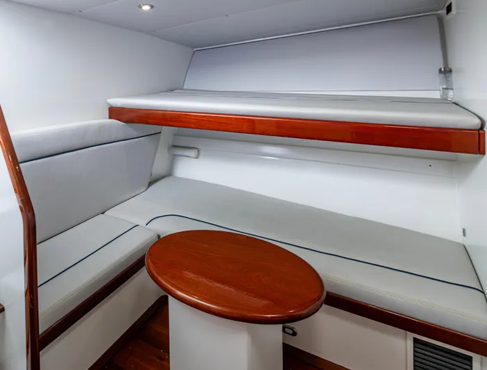 Slippery Slope Yacht Photos Pics Interior cabin of 2005 Gamefisherman 45 Express with wooden table and cushioned seating.