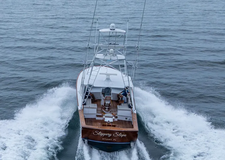 Slippery Slope Yacht Photos Pics 2005 Gamefisherman 45 Express yacht cruising on open water, rear view.