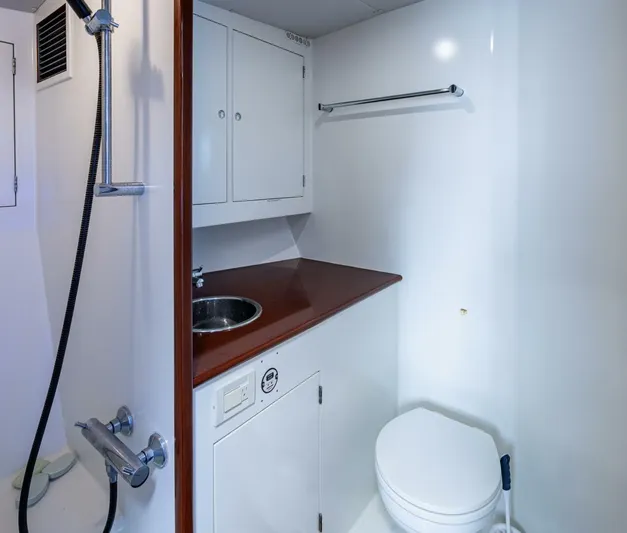 Slippery Slope Yacht Photos Pics Bathroom interior of 2005 Gamefisherman 45 Express yacht, featuring sink, shower, and toilet.