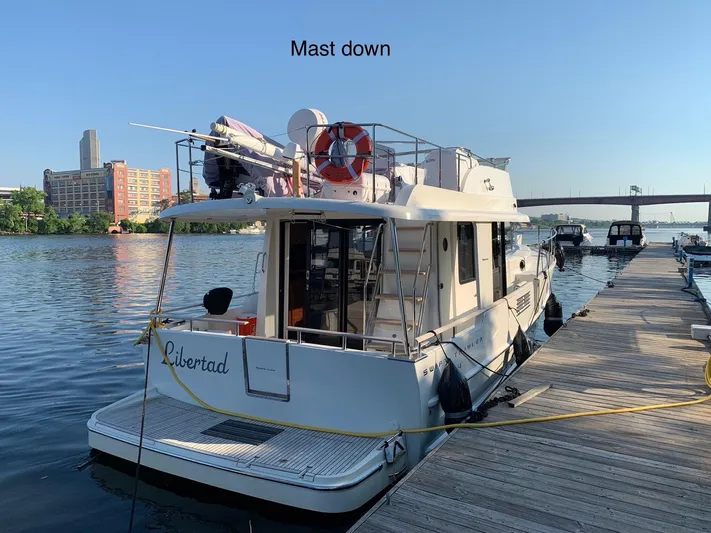 Libertad Yacht Photos Pics Beneteau Swift Trawler 44, 2020 model, docked with mast down, cityscape in background.