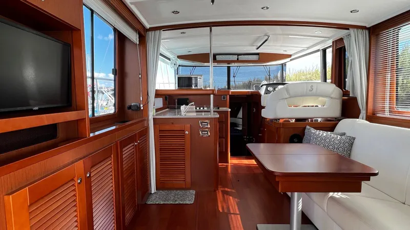 Libertad Yacht Photos Pics Interior of 2020 Beneteau Swift Trawler 44 with wood finish, seating, and kitchen area.