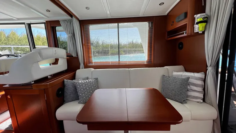 Libertad Yacht Photos Pics Interior of 2020 Beneteau Swift Trawler 44 with sofa, table, and window view.