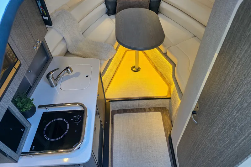  Yacht Photos Pics 2022 Monterey 295 Sport Yacht interior with kitchenette, seating, and ambient lighting.