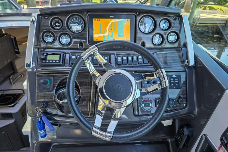  Yacht Photos Pics Steering console of 2022 Monterey 295 Sport Yacht with navigation display and controls.