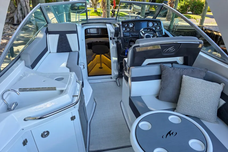  Yacht Photos Pics 2022 Monterey 295 Sport Yacht interior with seating, helm, and cabin entrance.