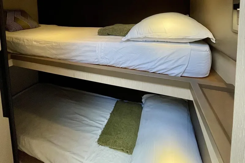  Yacht Photos Pics Bunk beds in 2017 Azimut 66 yacht cabin, featuring cozy white linens and pillows.