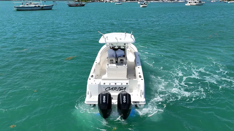  Yacht Photos Pics 2022 Boston Whaler 280 Outrage cruising on turquoise waters, rear view.