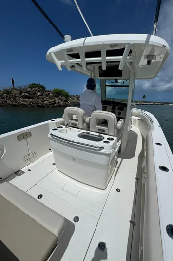  Yacht Photos Pics 2022 Boston Whaler 280 Outrage boat interior with helm and seating, under clear blue sky.