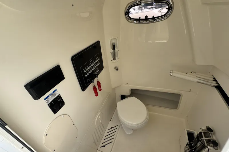  Yacht Photos Pics 2022 Boston Whaler 280 Outrage interior cabin with toilet and control panel.